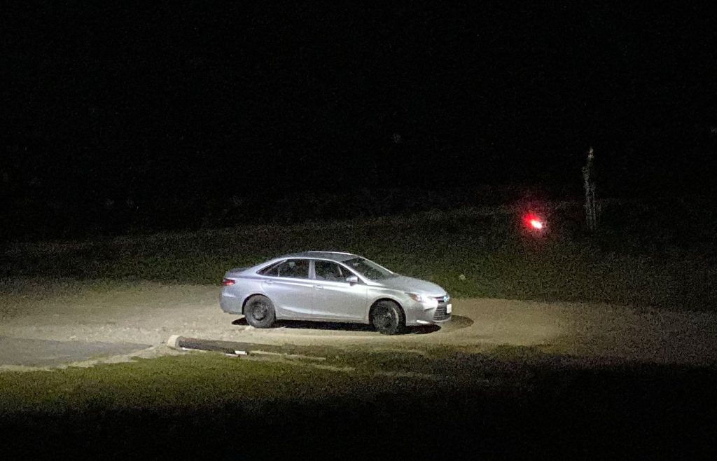 Vehicle illuminated at night with a drone